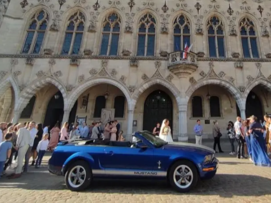 Arrivée des mariés en Ford Mustang décapotable devant un bel édifice