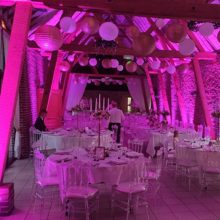 Salle de réception illuminée de lanternes et d'une ambiance rose chaleureuse